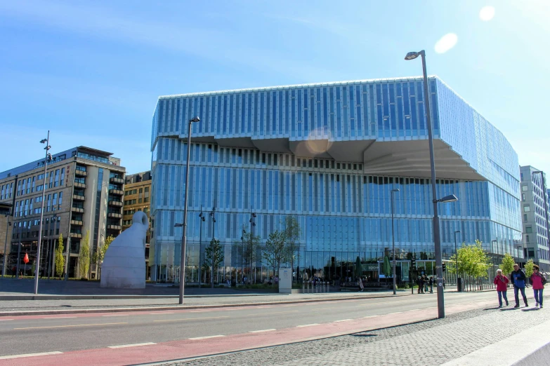 a group of people walking outside of a building with glass