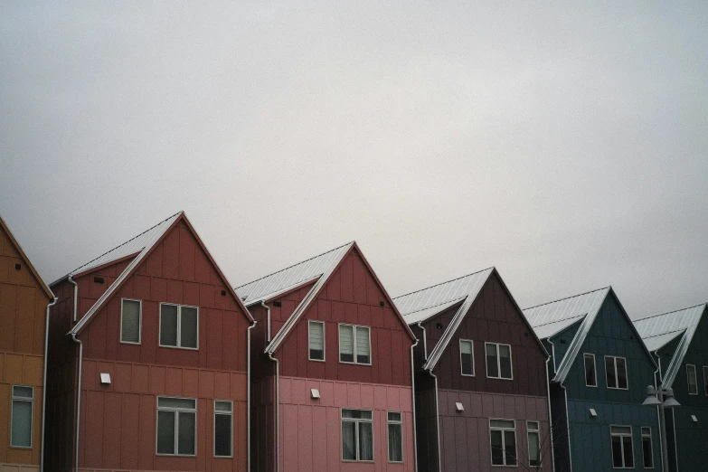 rows of old red and blue houses against a cloudy gray sky