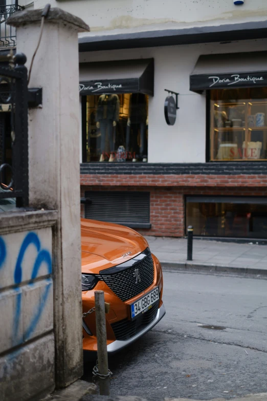 an orange car parked next to a building