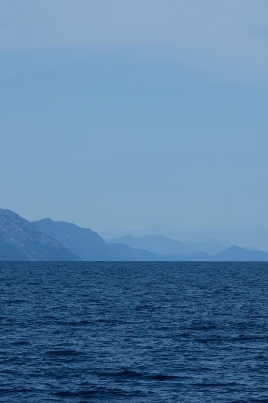 a boat in the water with mountains behind it