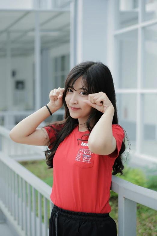 young asian woman posing on balcony with house in background