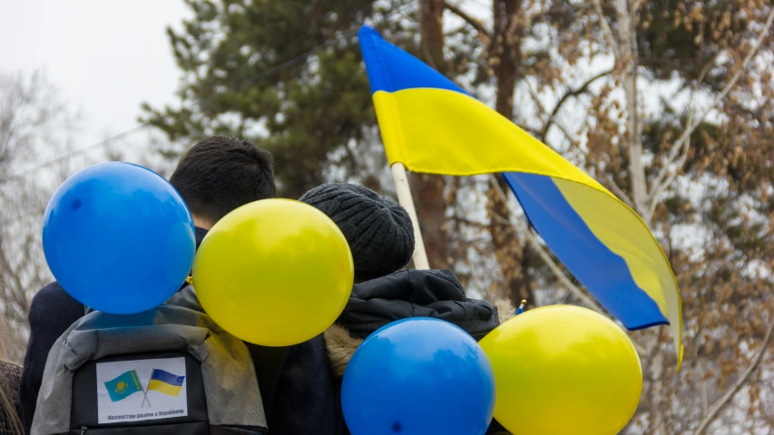 two people standing in the snow with balloons