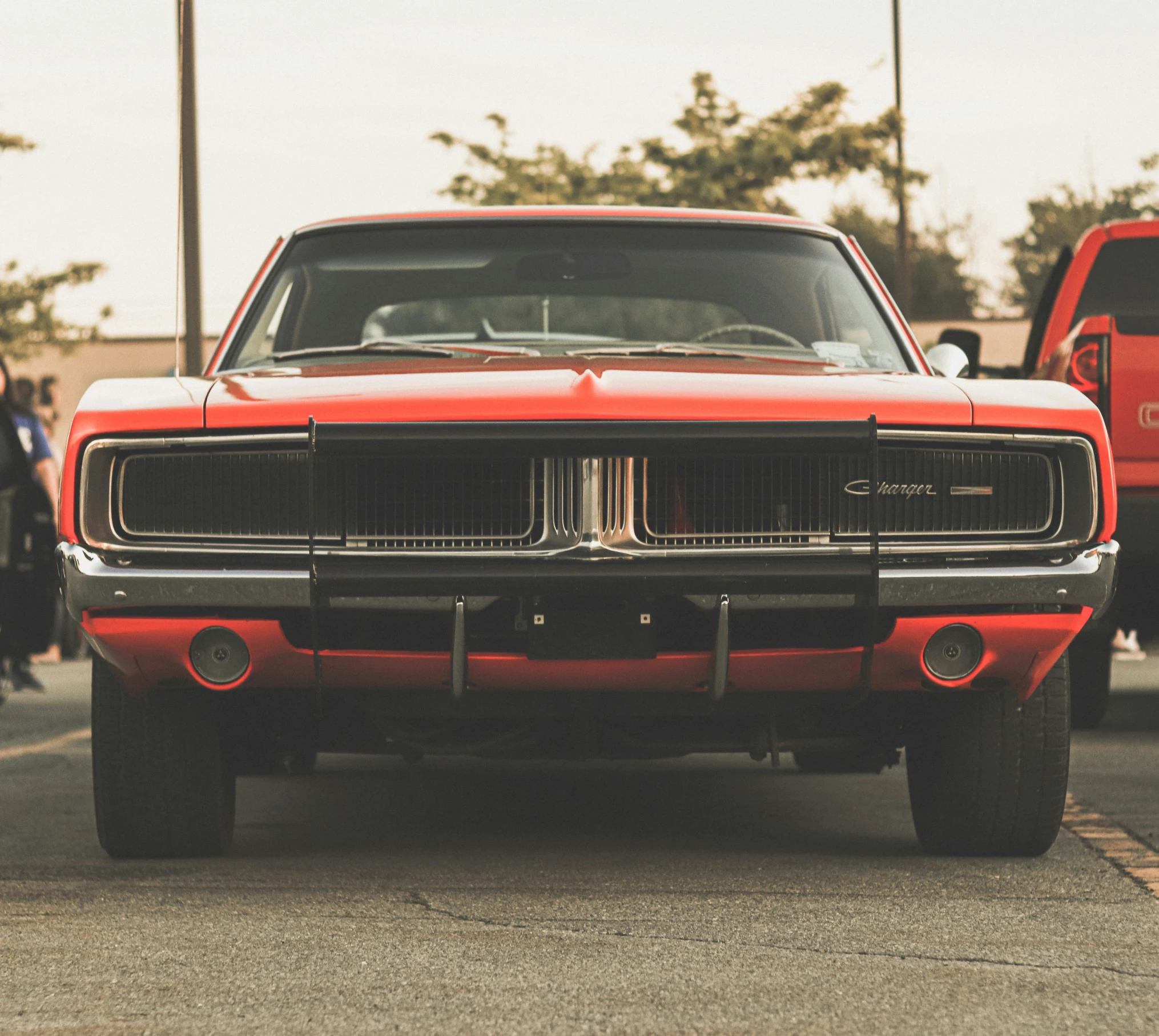 a red vintage mustang is sitting in a parking lot