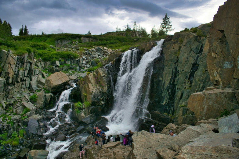 a waterfall with people walking up the side of it