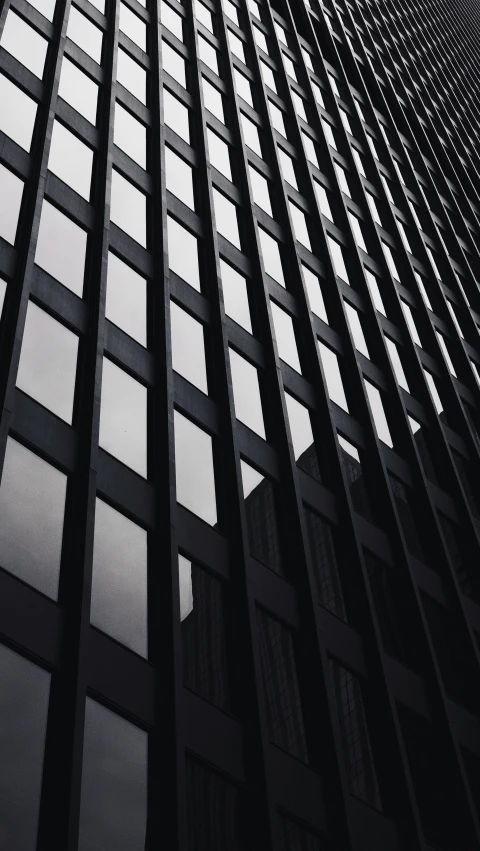 building is made of geometric glass and has multiple balconies on the windows