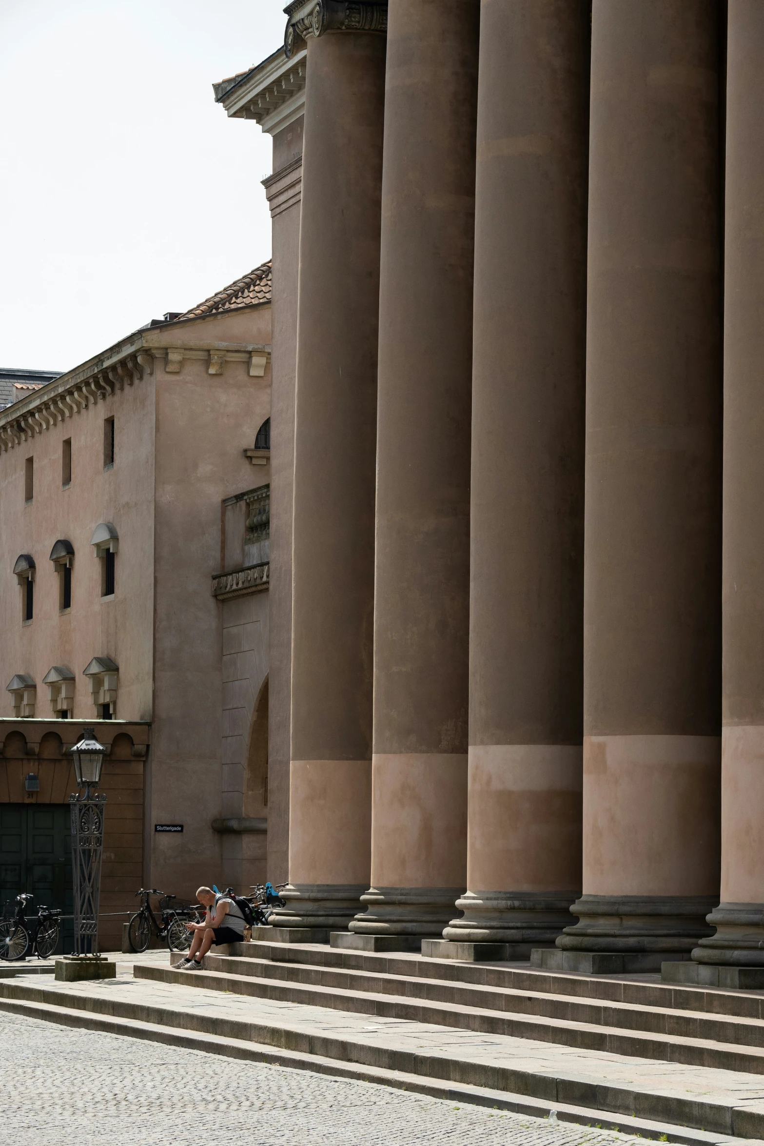 three men sitting on the steps looking at the buildings