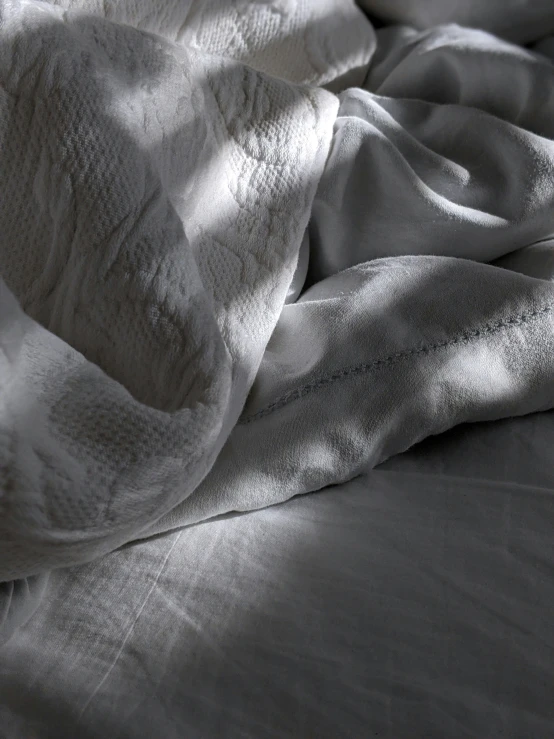 black and white pograph of sheets folded up on bed