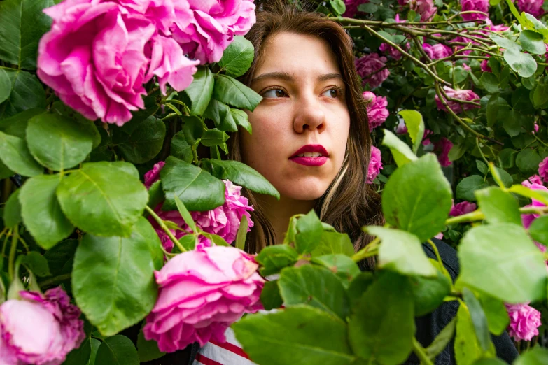 a girl with her mouth out looking at flowers