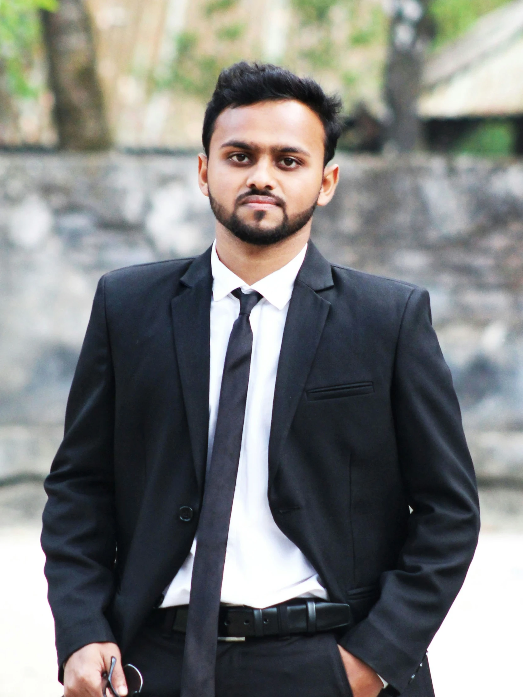 a man in a suit standing and looking at the camera