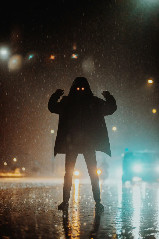 a person standing in the rain holding their hand up