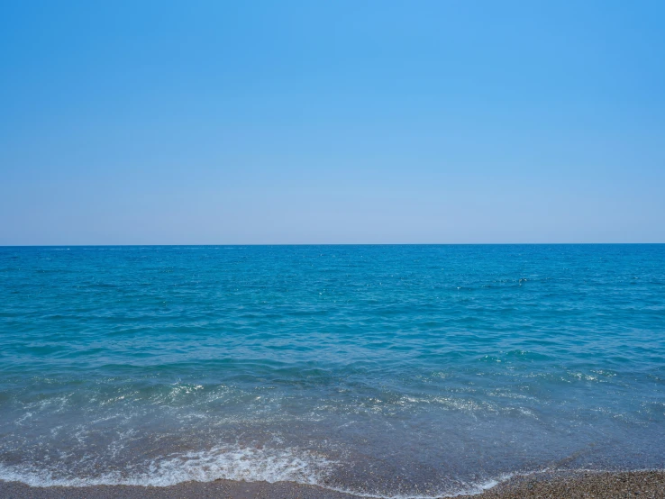 the beach is clear and blue with the ocean in the distance