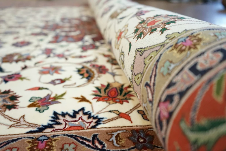 a close - up of a multi colored rug with a brown table top in the background