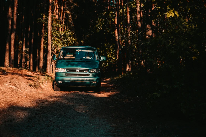 a blue truck parked in the middle of a wooded area