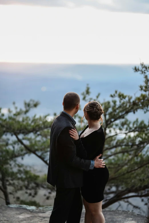 the man is standing near the woman by the tree