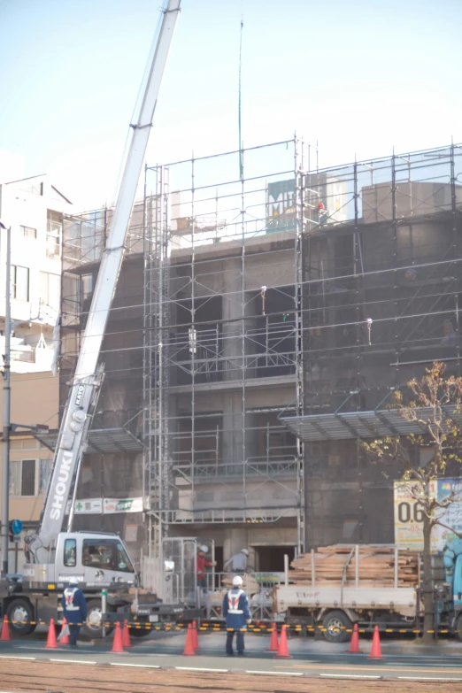 a large crane being hoisted over by some construction equipment