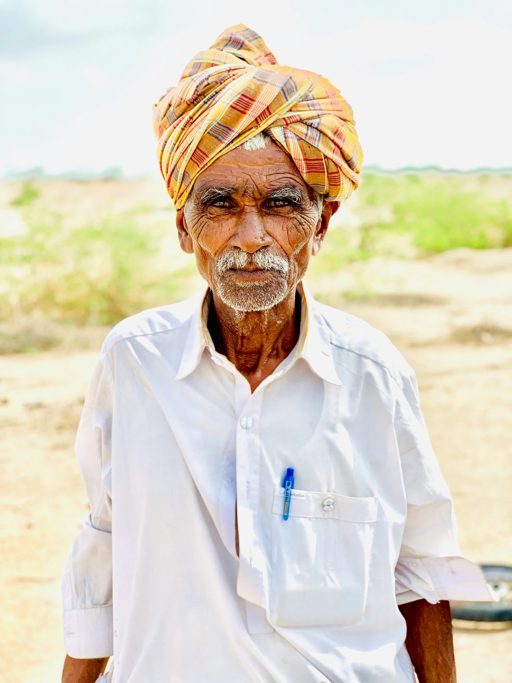 an older man wearing a turban in a desert