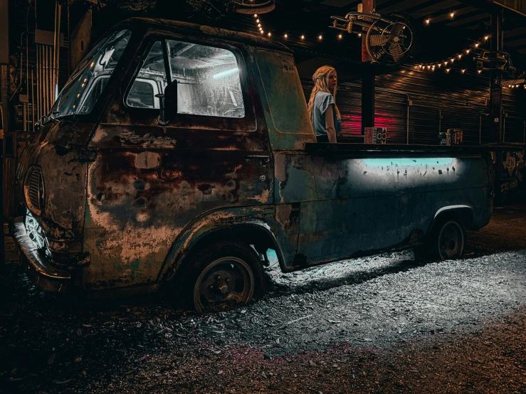 a person stands in the driver seat of an old truck