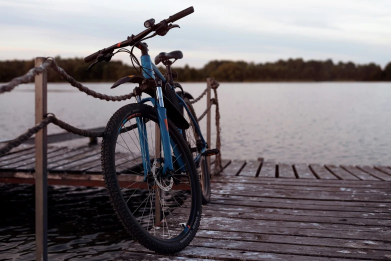 a bicycle leans up against the end of a dock