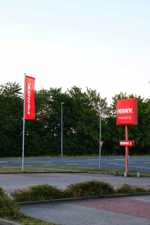 a road side with three red signs at a parking lot