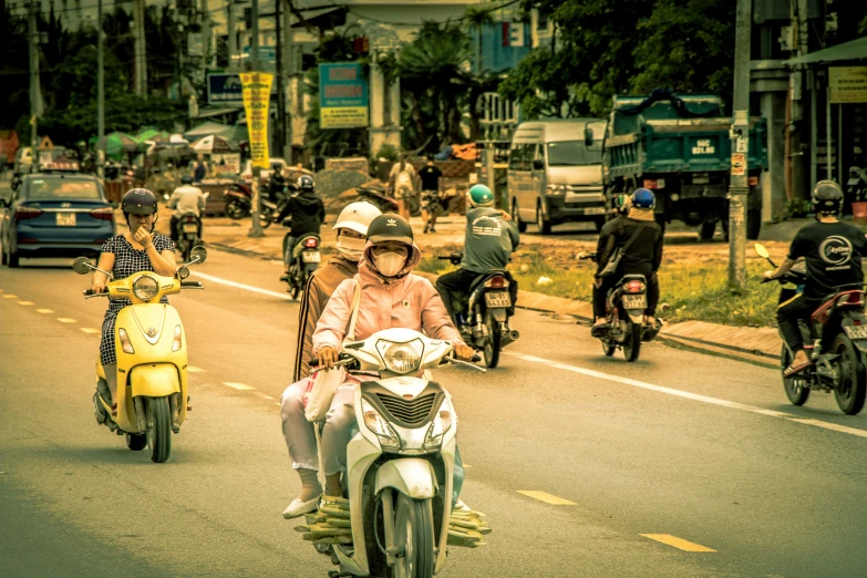 a group of people riding scooters on a road