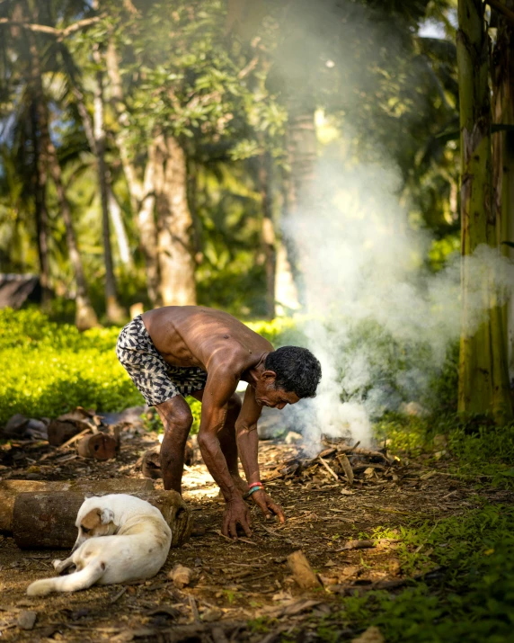 there is a man bending over next to two dogs