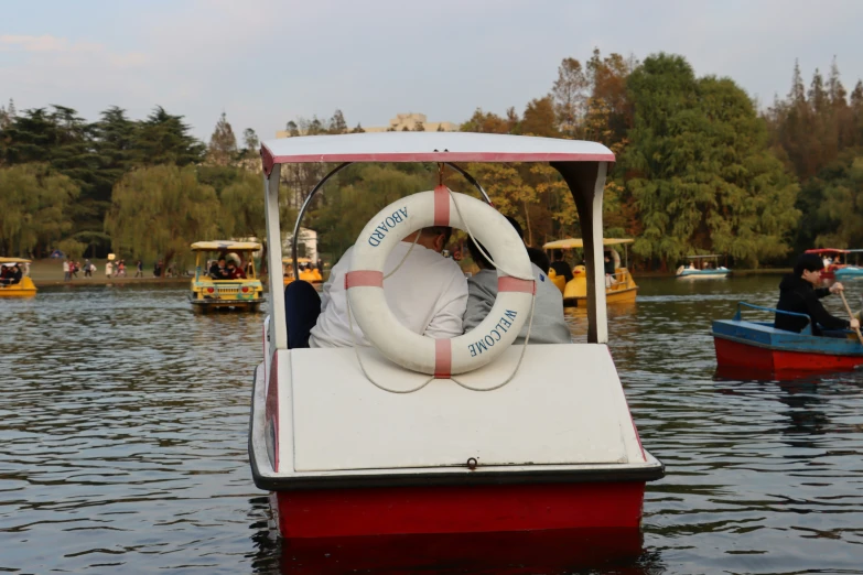 a life preserve is on the water, in which three people row canoes