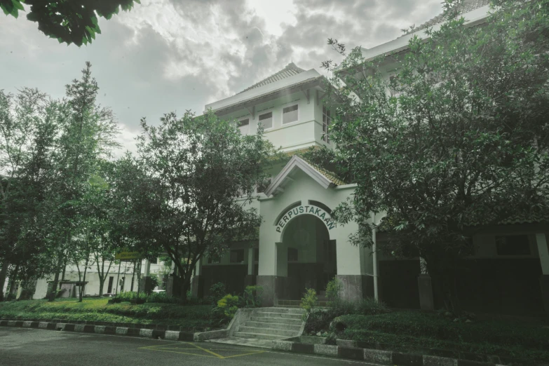 the building with the arched roof has trees surrounding it