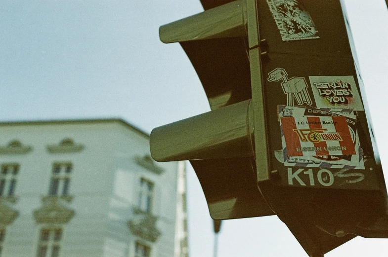 a pole with a street light with several stickers on it