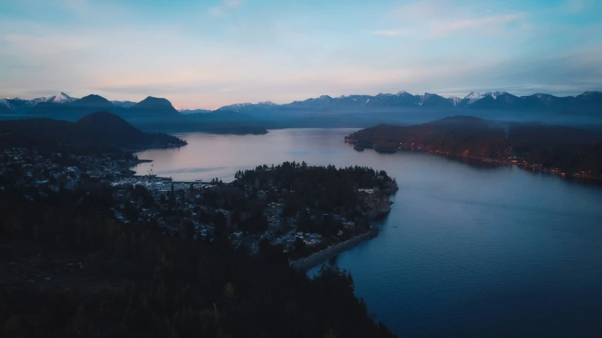 an aerial po of the lake with mountains in the background