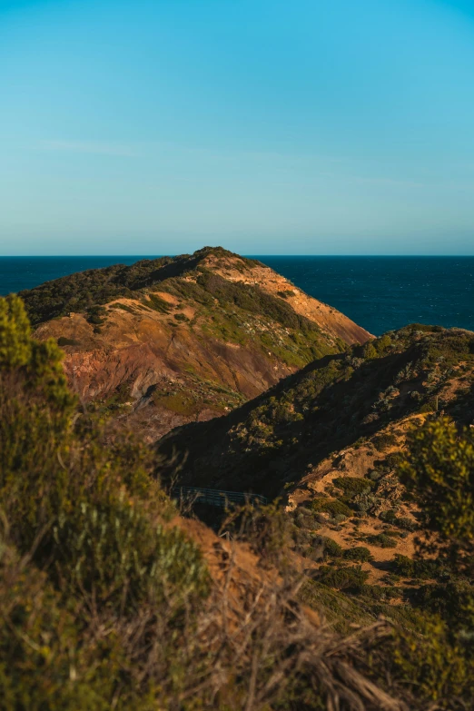 a landscape image of several hills on top of the ocean