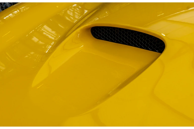 a close up of the front end of a yellow sports car