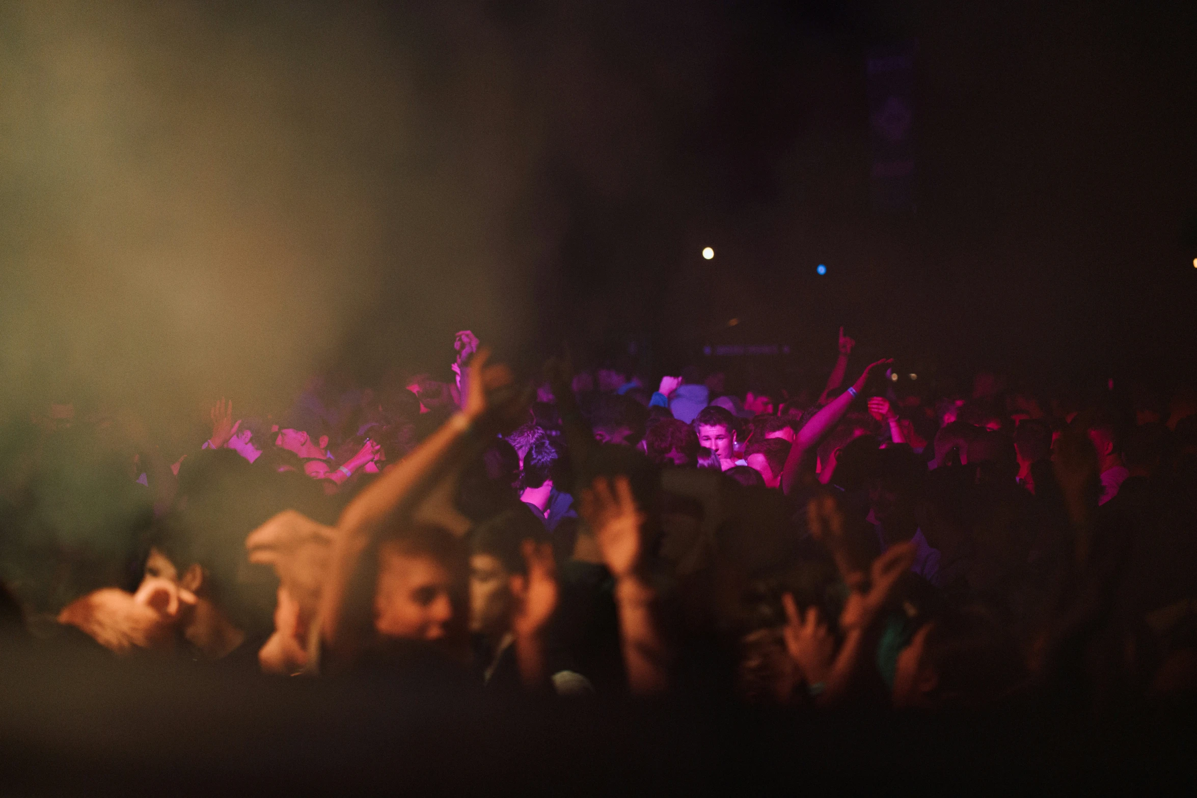 a crowd watching a concert on stage with their arms in the air