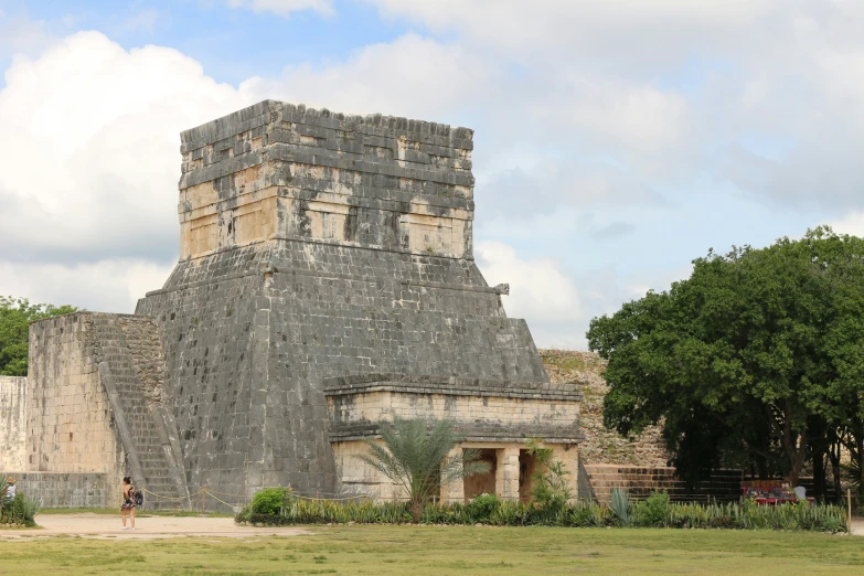 large brick structure surrounded by a tall tree