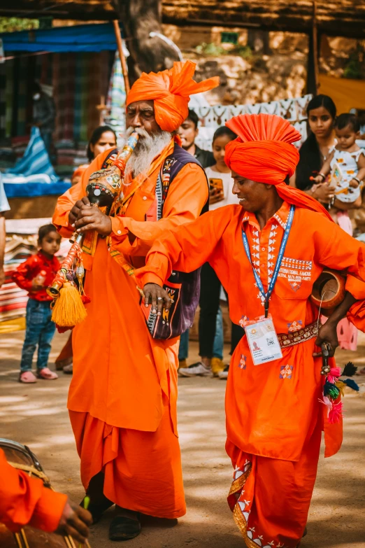 the two monks have bright orange clothing, as well as white hair