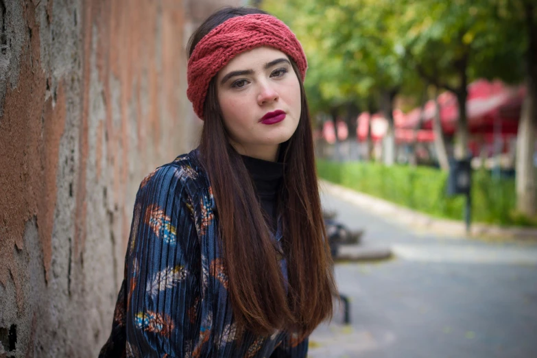 woman in floral coat with red scarf posing for po