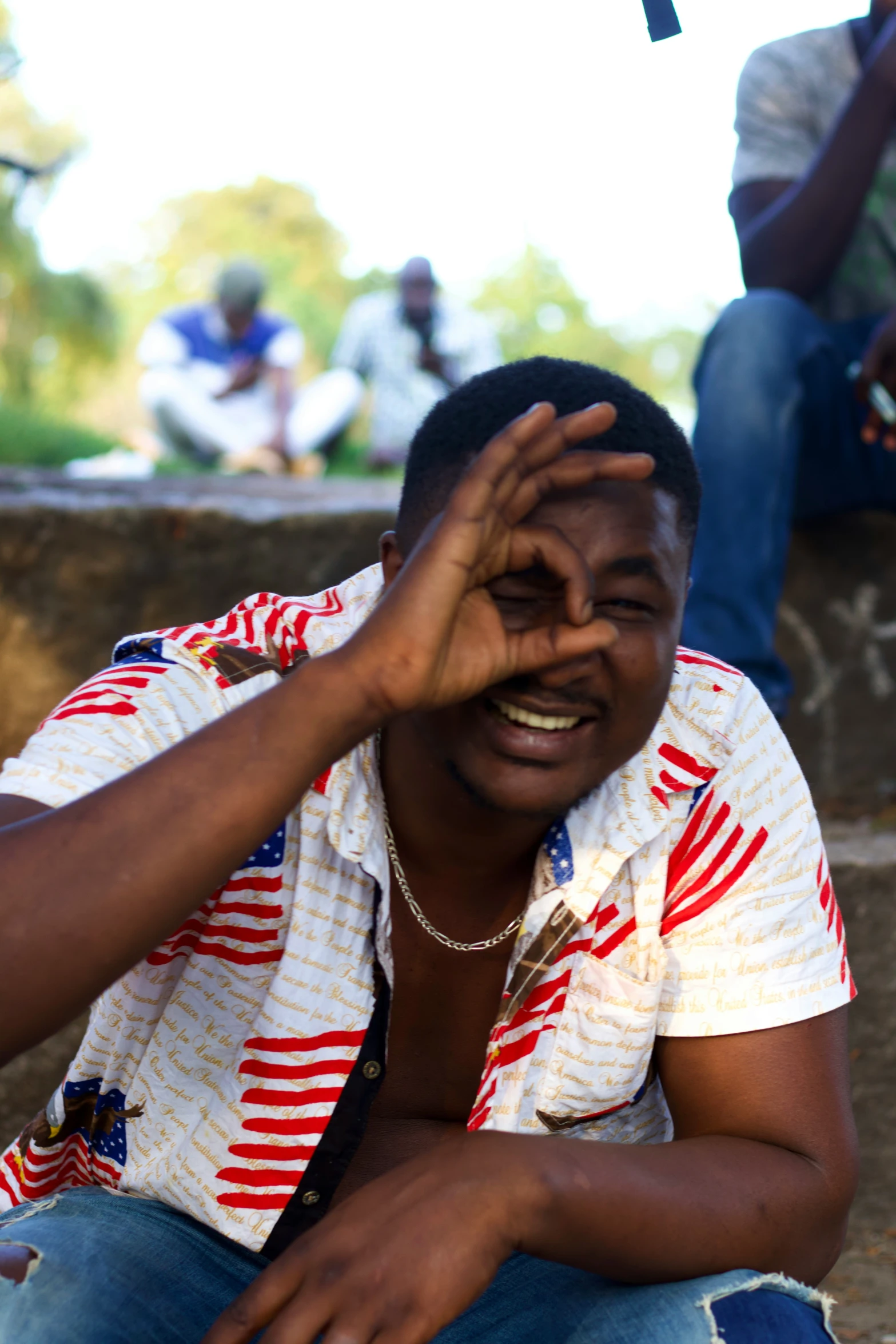 a man is sitting on steps with his hand over his eye