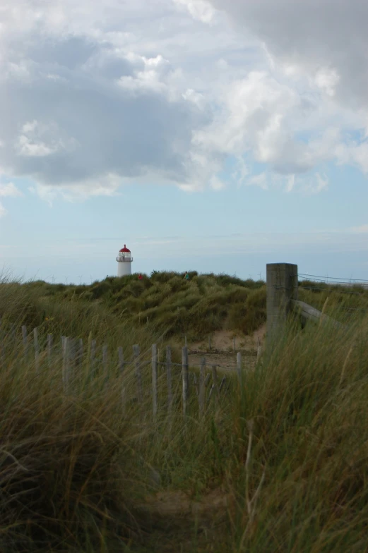 a lighthouse on top of a grassy hill