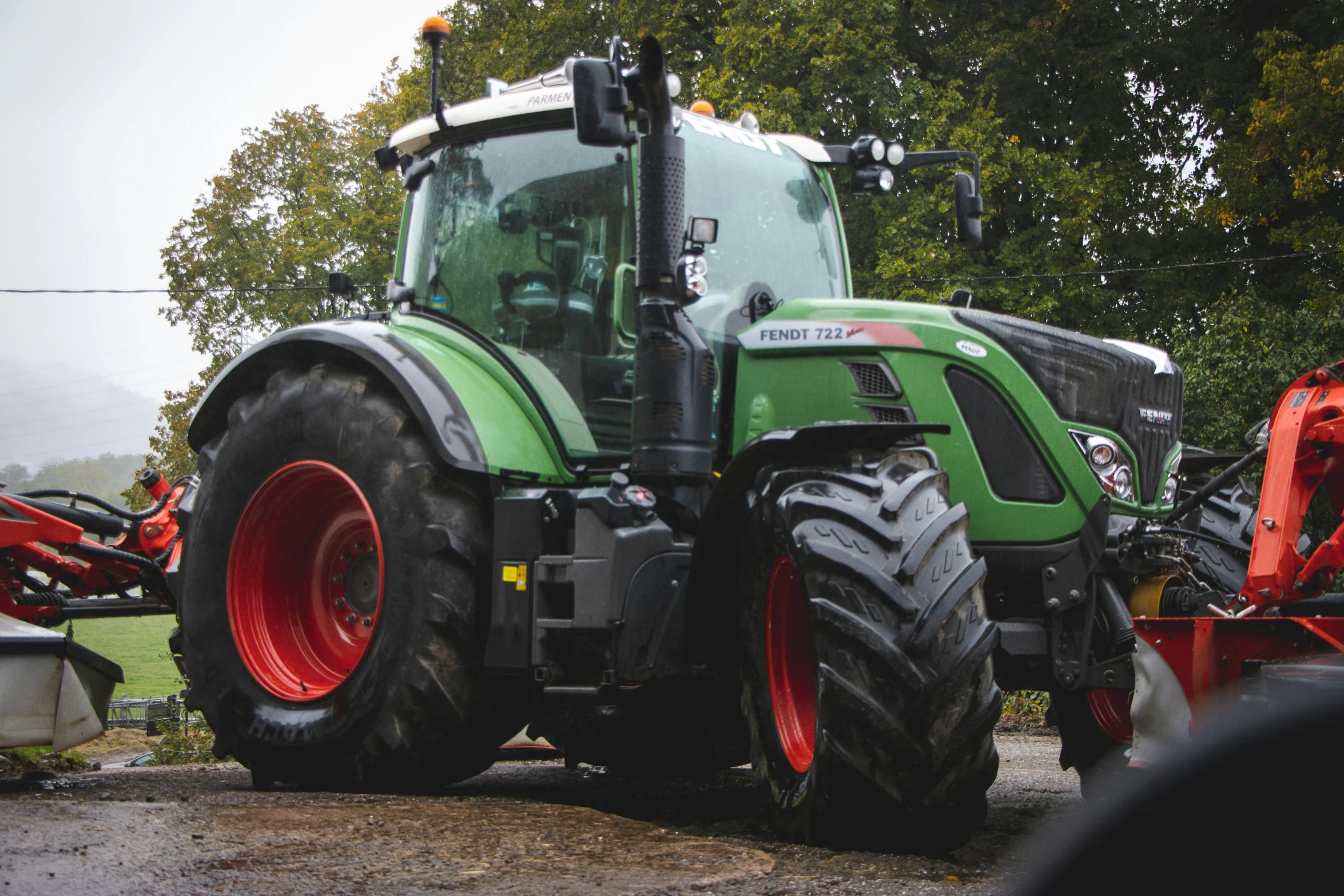 a tractor with two farm equipment sitting on it