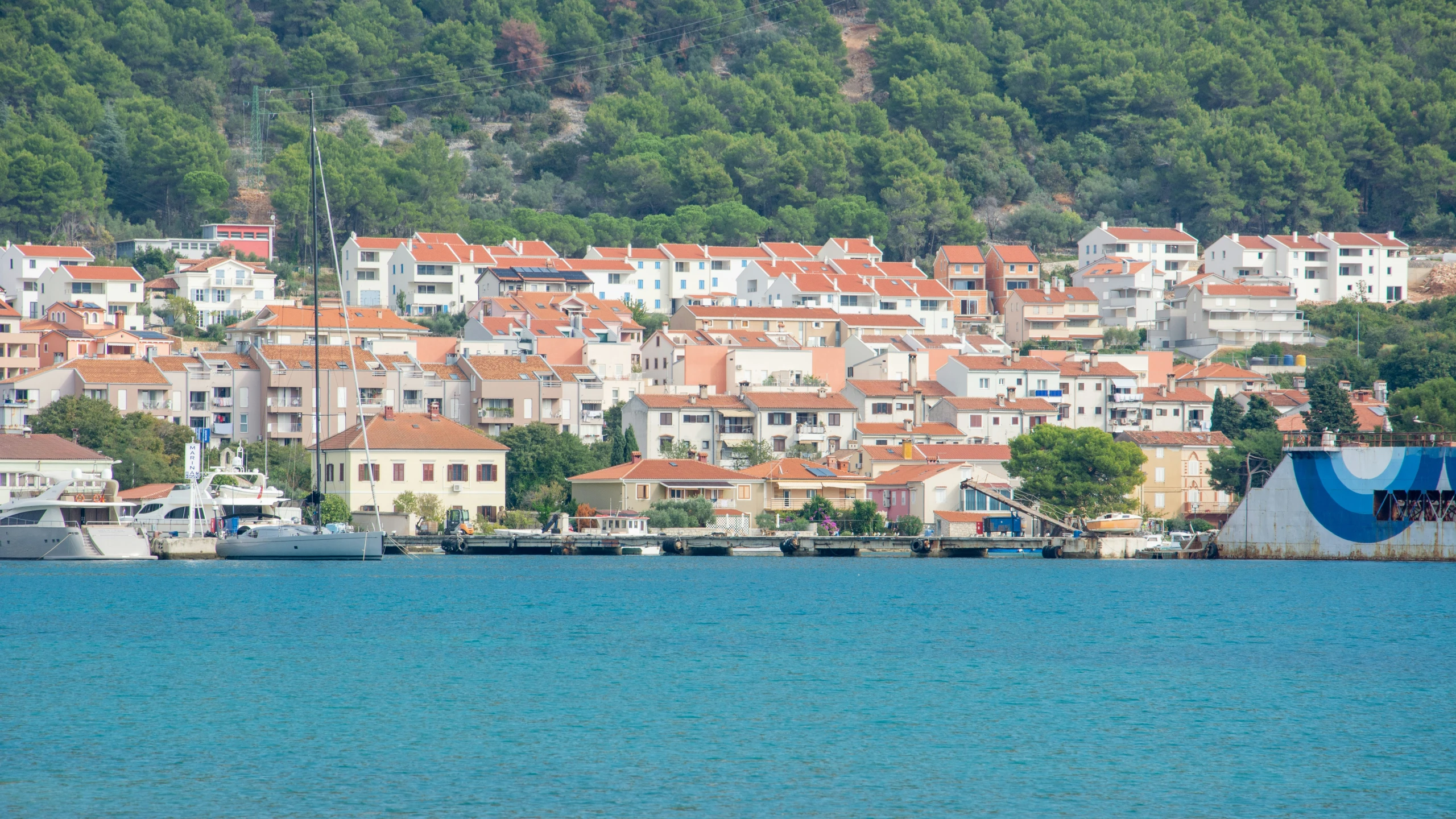 boats and yachts are on the water outside a city