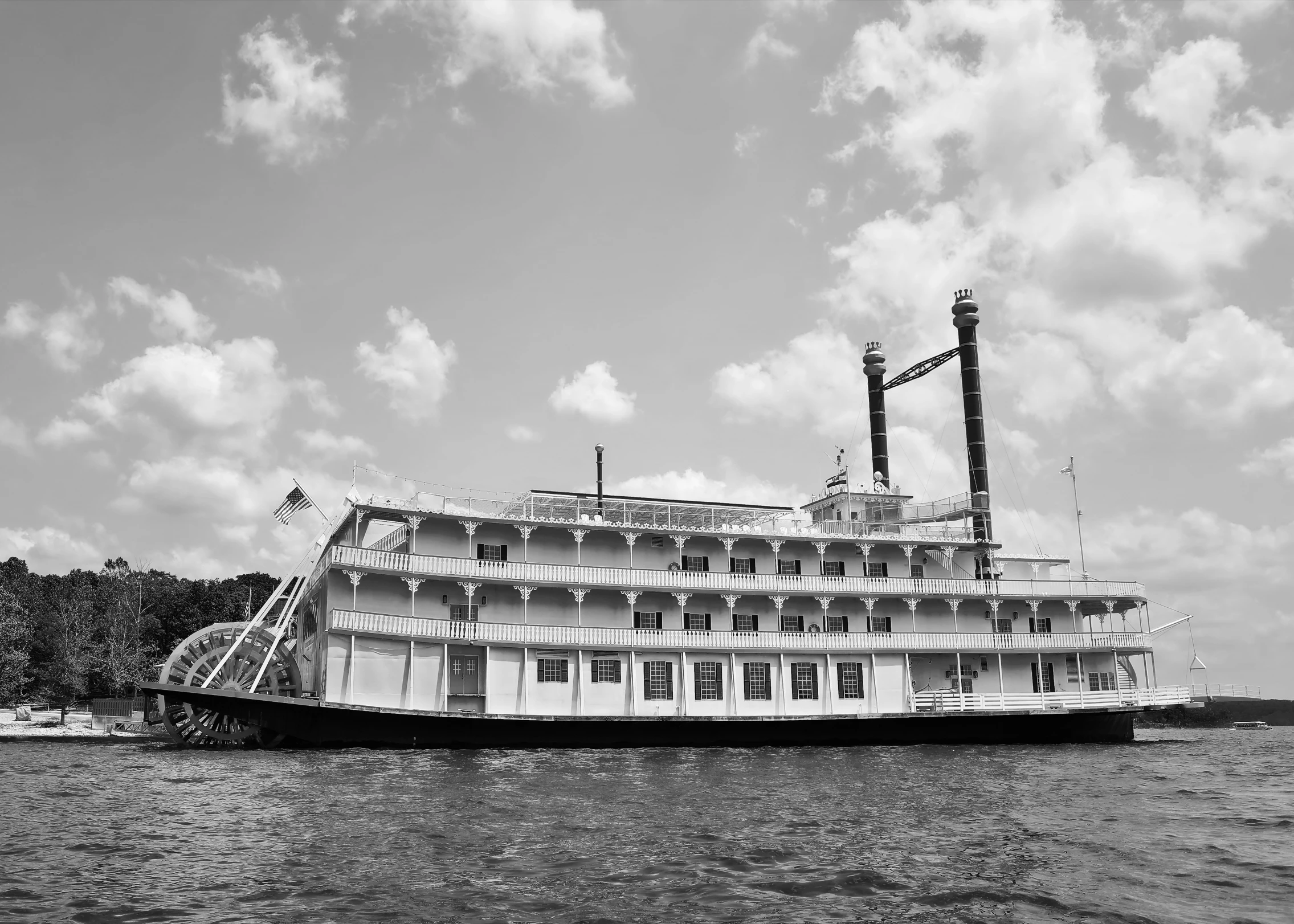 the boat is docked in water near some trees