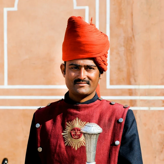 a man wearing an indian turban stands in front of a building