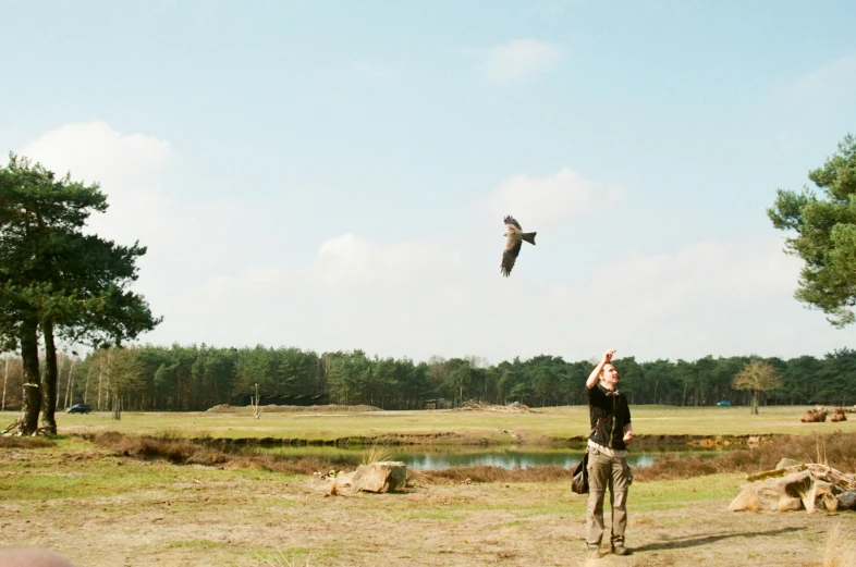 a man holding up a bird in the sky