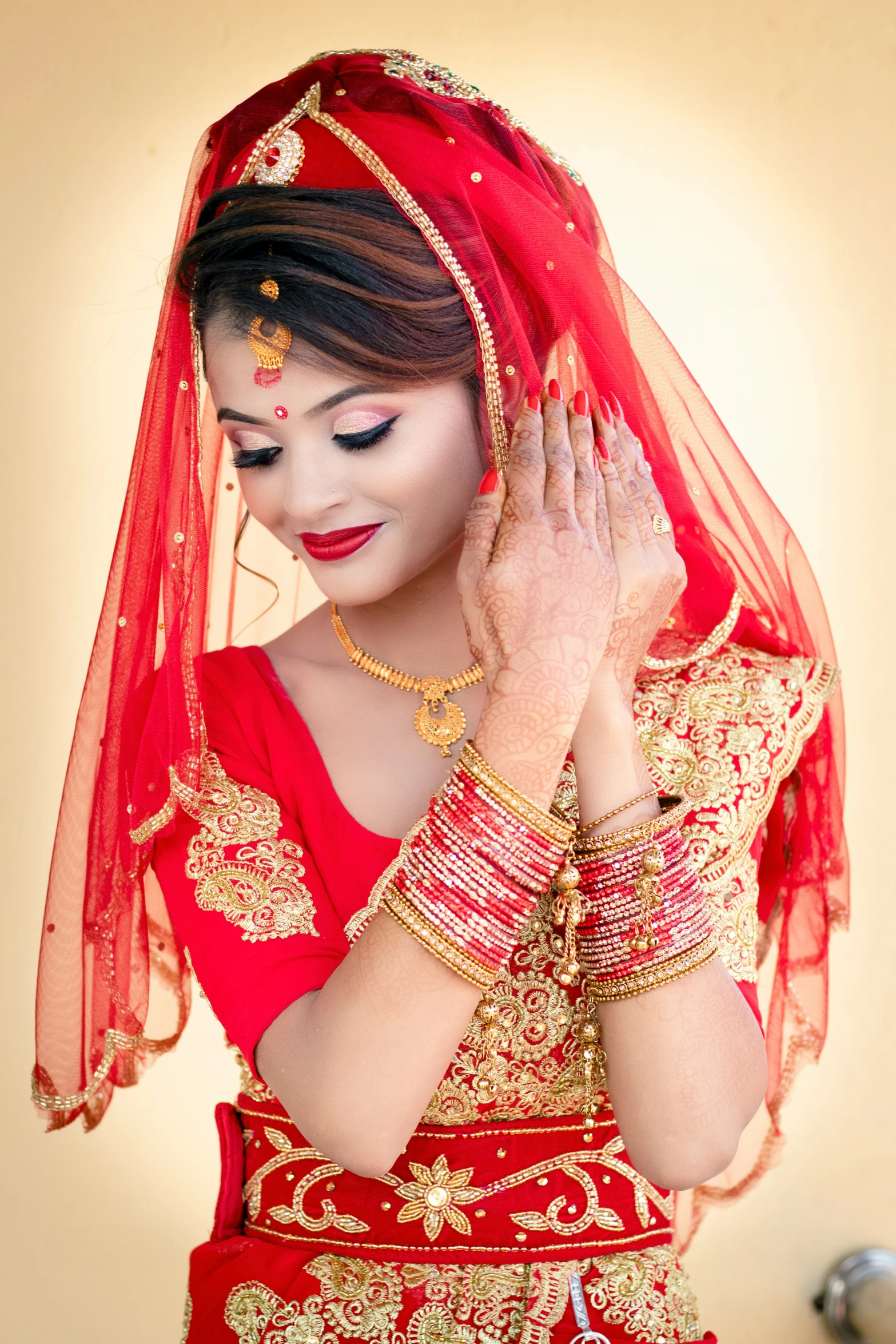 a woman in a red and gold outfit holding a wedding ring