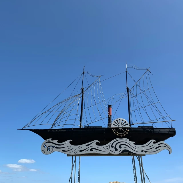 a large black ship model standing next to some rocks