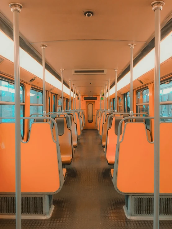 an orange seat on the side of a long bus