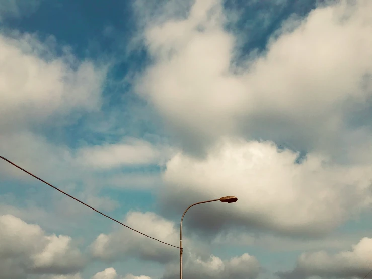 clouds above power line and lightpost in urban area