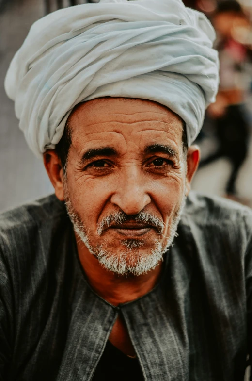 a man wearing a turban sitting down and looking up