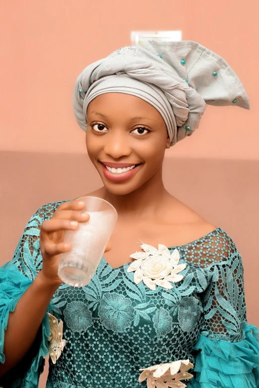 a beautiful woman in a green dress holding a glass