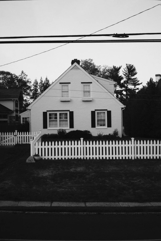 an old house sitting beside a white picket fence