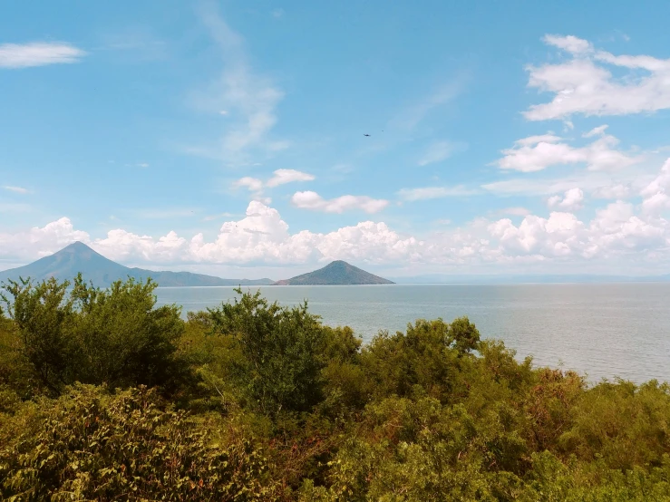 a view from some hills, the water and mountains in the background